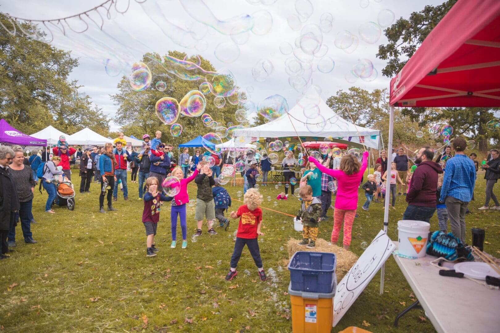 Outdoor festival with children playing and bubbles.